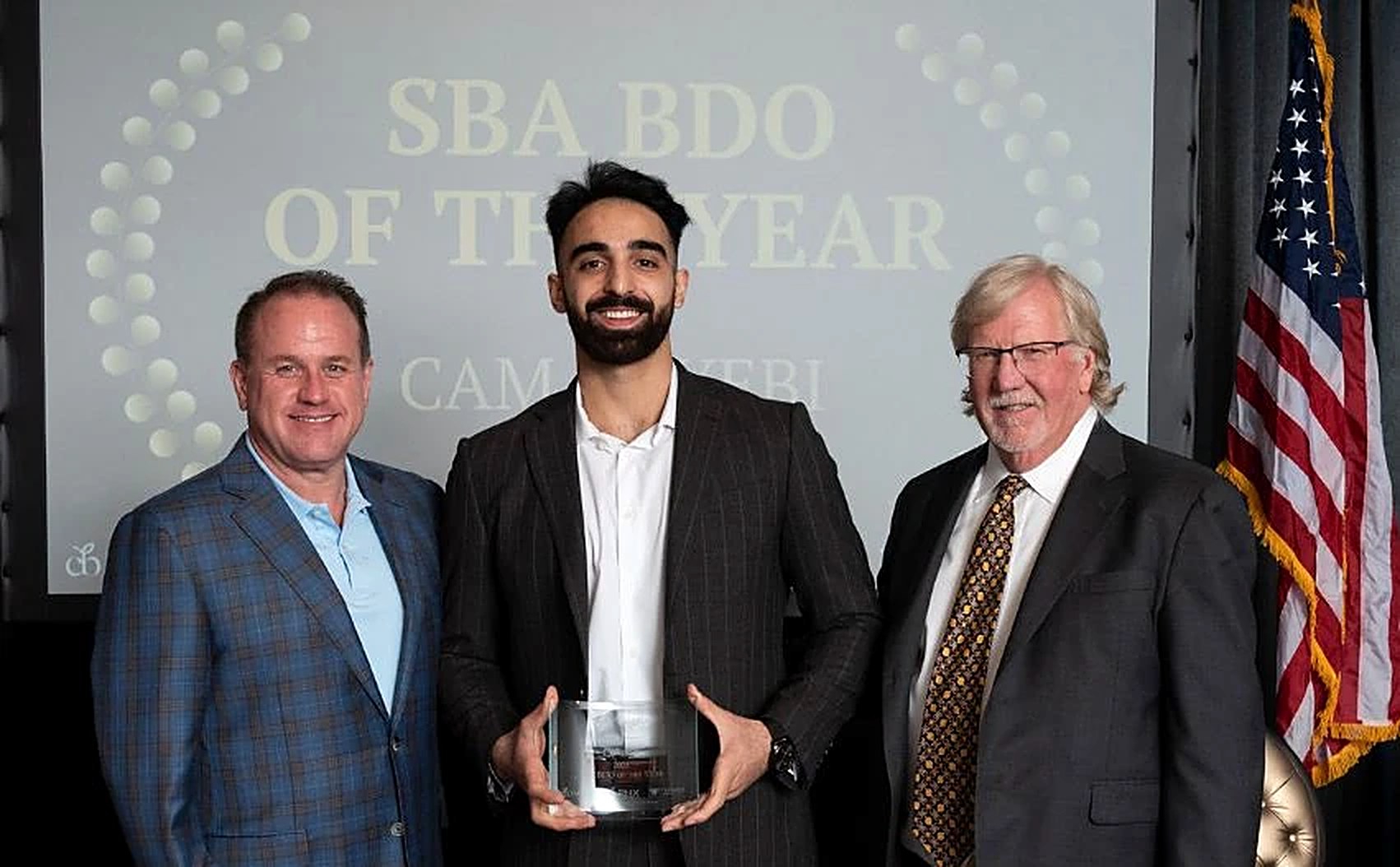 Cam Nayebi on stage holding the SBA BDO of the Year award